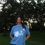 Person wearing a blue t-shirt with a white design outdoors