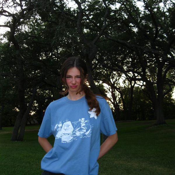 Person wearing a blue t-shirt with a white design outdoors