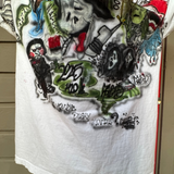 White t-shirt with colorful graphic designs on a person wearing it.