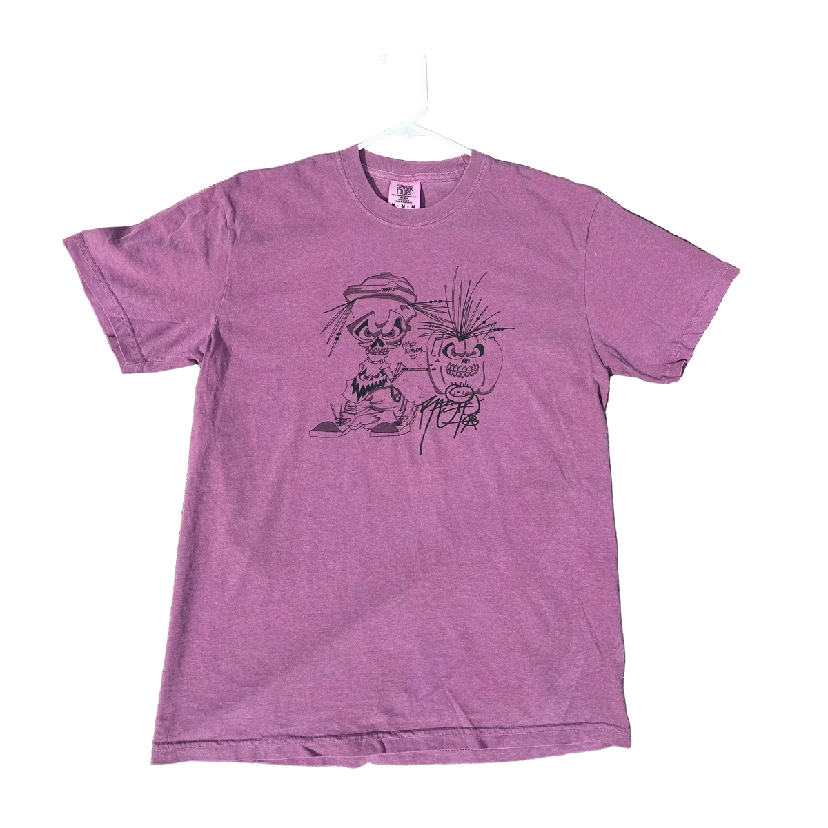 Purple t-shirt with a graphic design on a concrete surface
